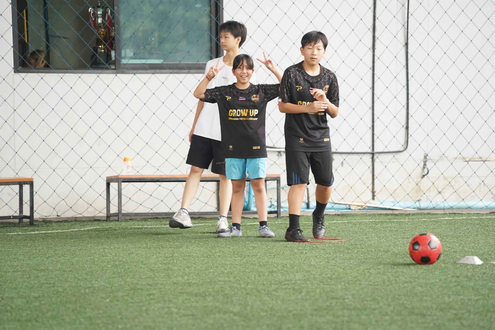 Kids in Grow Up Football Camp Chiang Mai jerseys on the training pitch